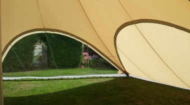 De binnenkant van een StarShade 400 feesttent met twee zijpanelen. Eén vol en één transparant.